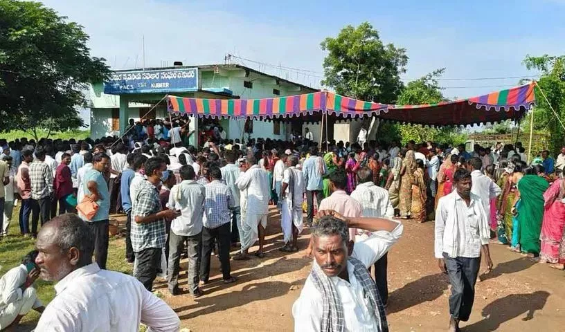 निर्मल जिले के सोयाबीन खरीद केंद्र पर भगदड़ के बाद घायल महिलाओं को मदद करते लोग