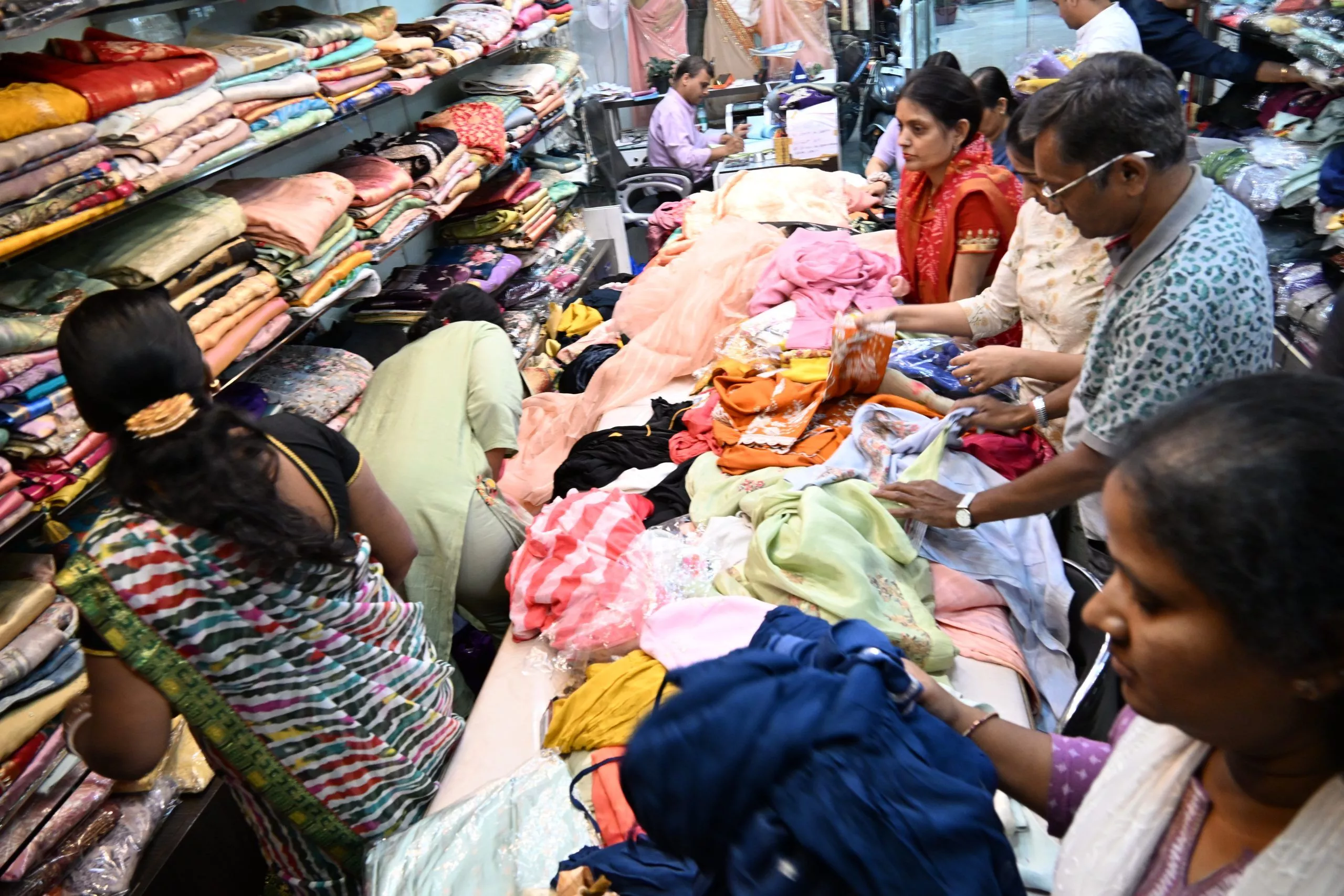 पूजा साड़ी स्टोर में साड़ियों की सेल का दृश्य