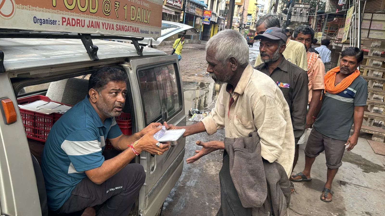 जरूरतमंदों को भोजन वितरित करते स्वयंसेवक