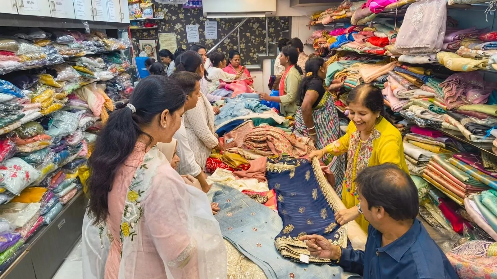 पूजा साड़ी स्टोर में साड़ियों की सेल का दृश्य