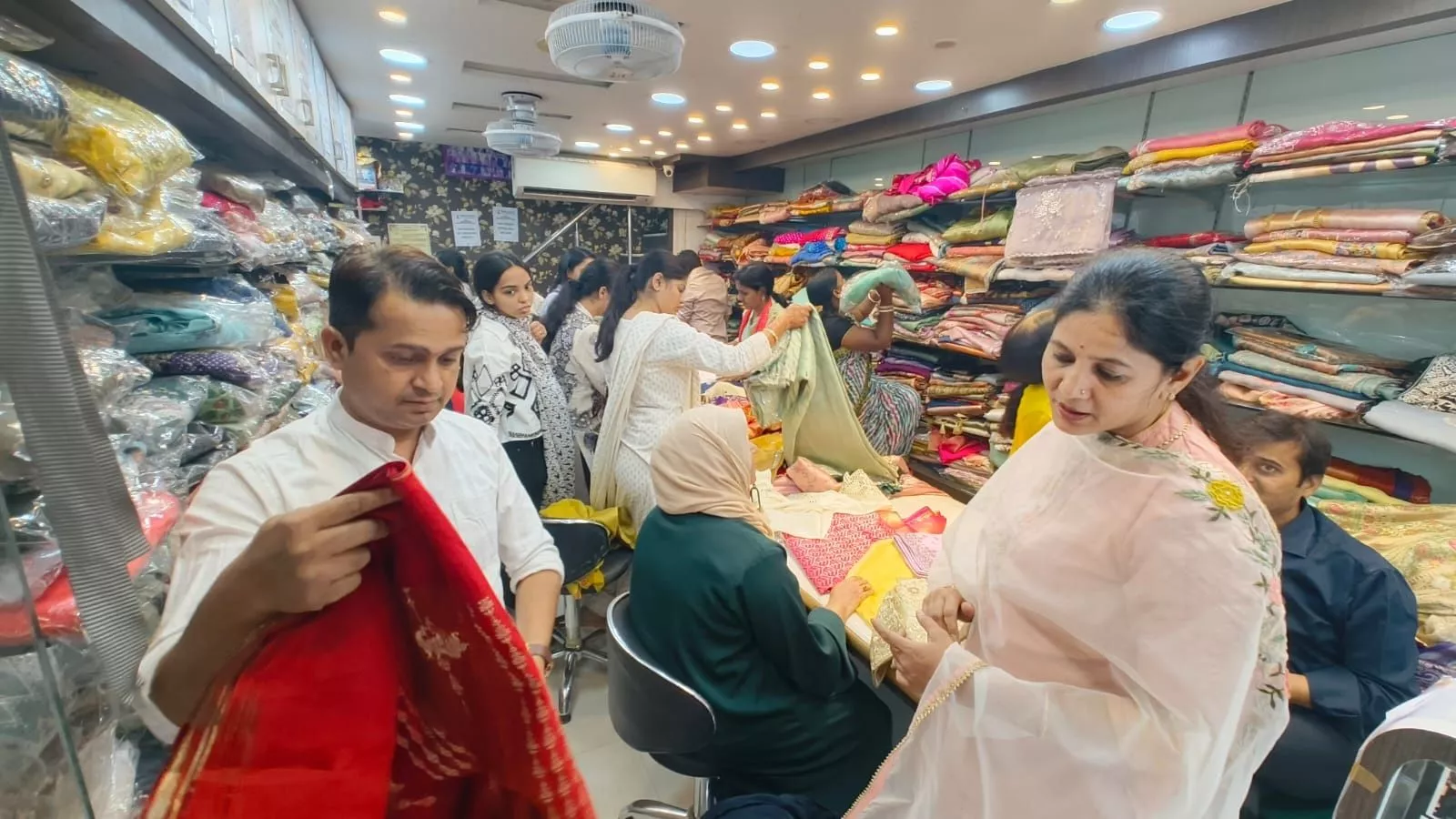 पूजा साड़ी स्टोर में साड़ियों की सेल का दृश्य