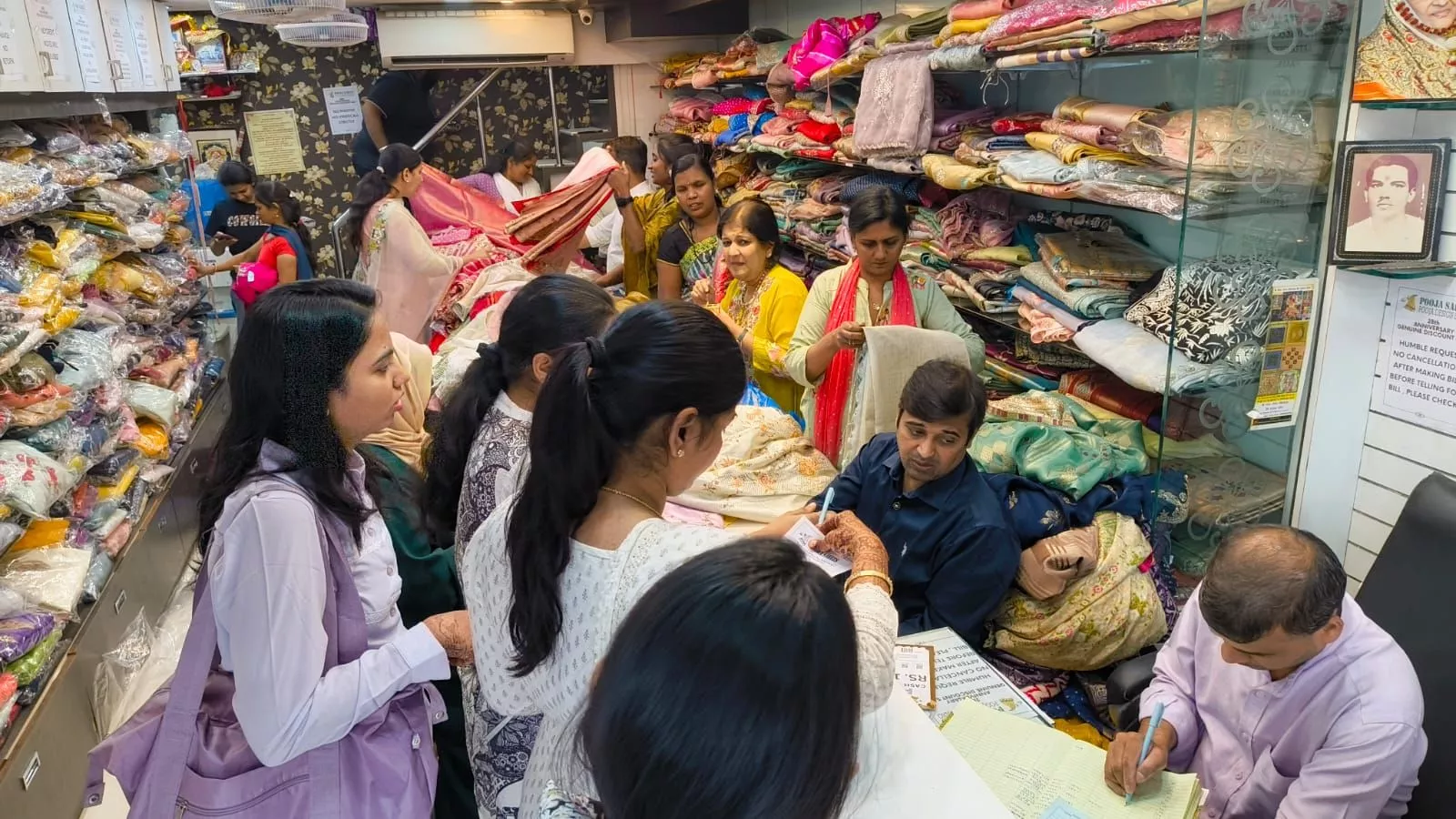 पूजा साड़ी स्टोर में साड़ियों की सेल का दृश्य