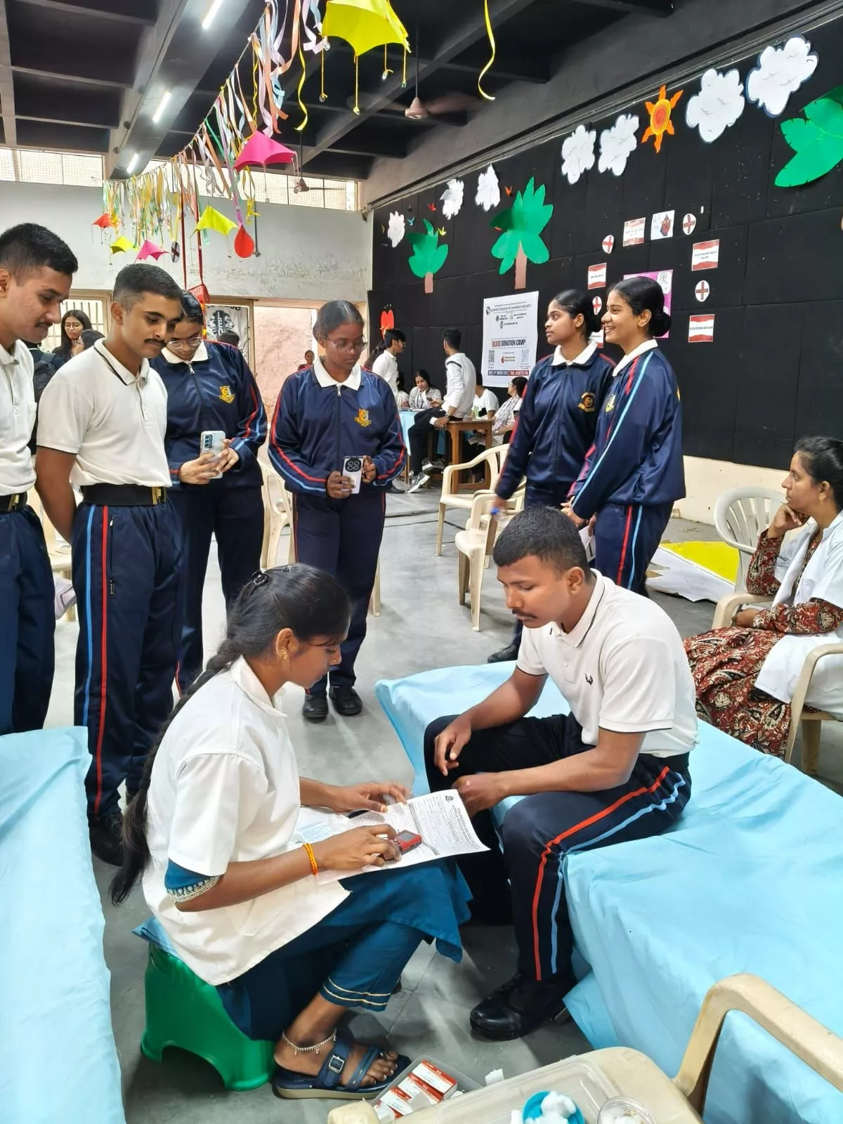 छात्र और शिक्षक रक्तदान करते हुए, सामाजिक जिम्मेदारी का संदेश