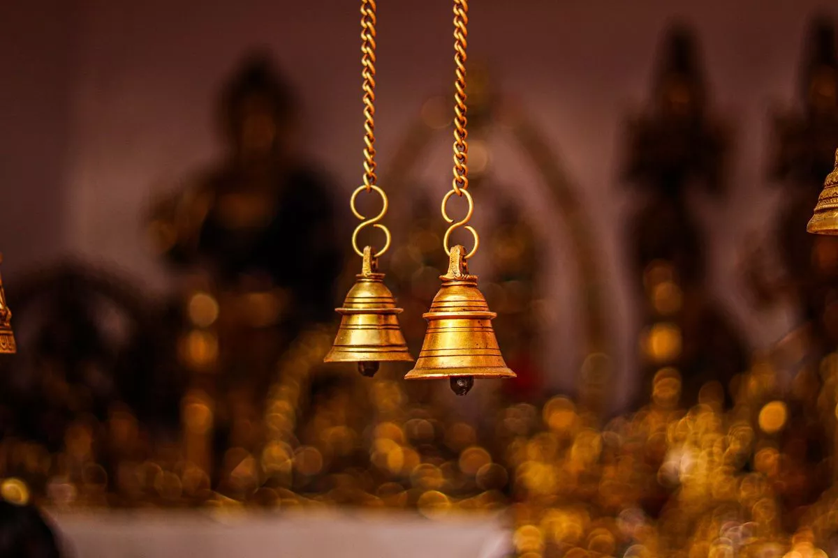 मंदिर में भक्त द्वारा घंटी बजाते हुए दृश्य
