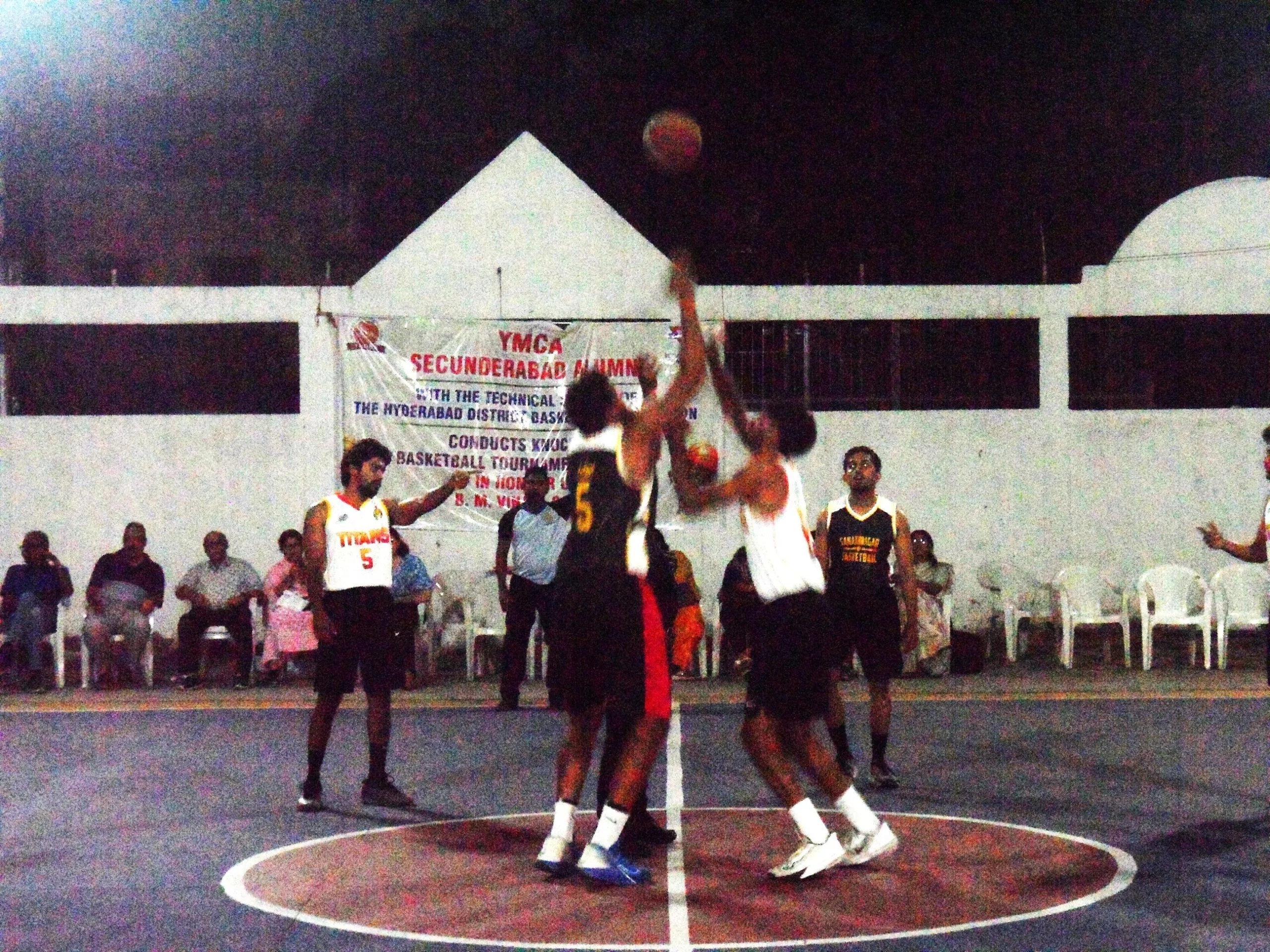 बास्केटबॉल मैच में खेलते वाईएमसीए और टाइटन्स खिलाड़ी