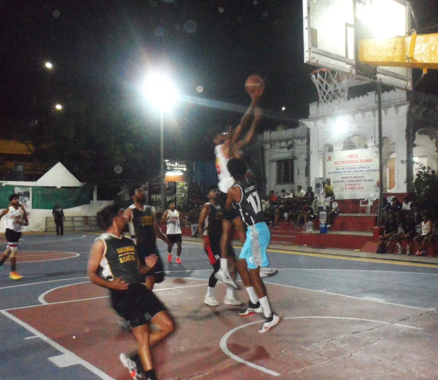 बास्केटबॉल मैच में खेलते वाईएमसीए और टाइटन्स खिलाड़ी