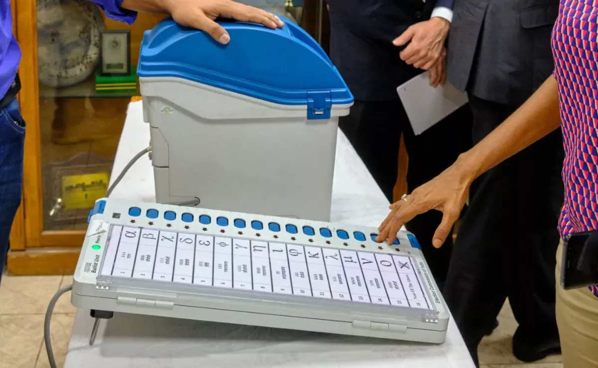 ईवीएम मशीन पर बटन दिखाता मतदान दृश्य