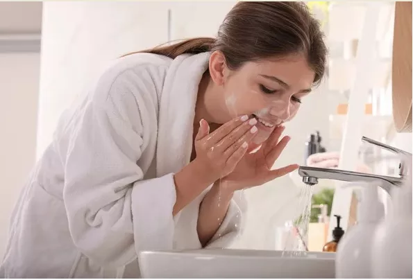 रात में स्किन केयर रूटीन करते हुए महिला