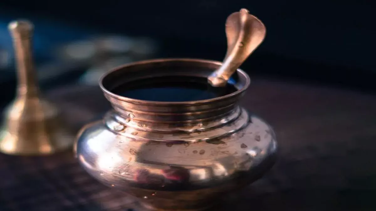 पूजा घर में तांबे के लोटे में रखा पवित्र जल