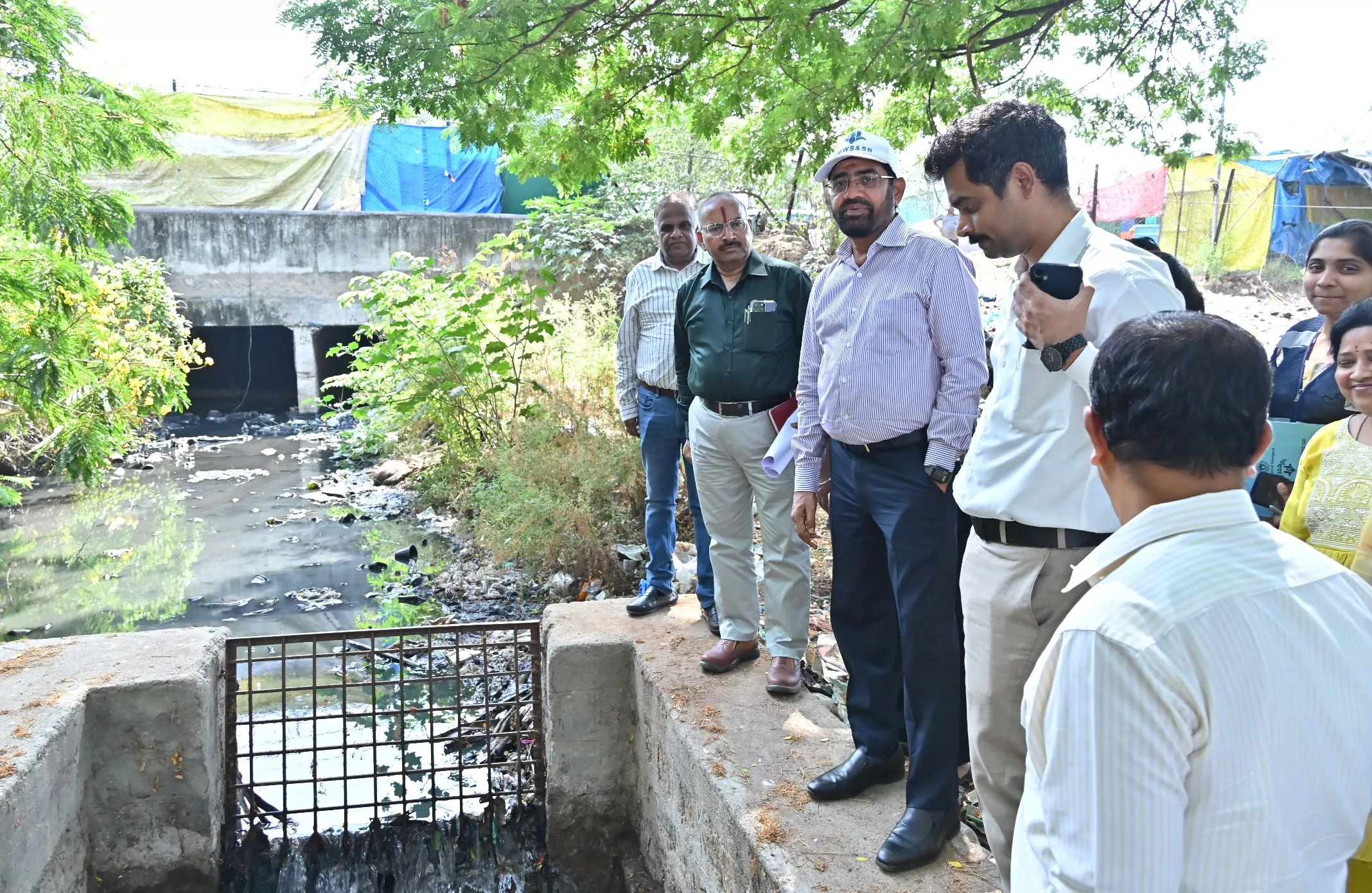 सीवर पाइपलाइन कार्य का निरीक्षण करते अधिकारी