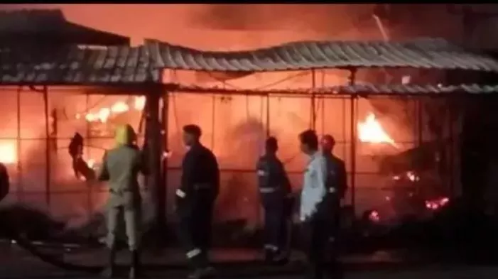 आग में जलती दुकानों का दृश्य